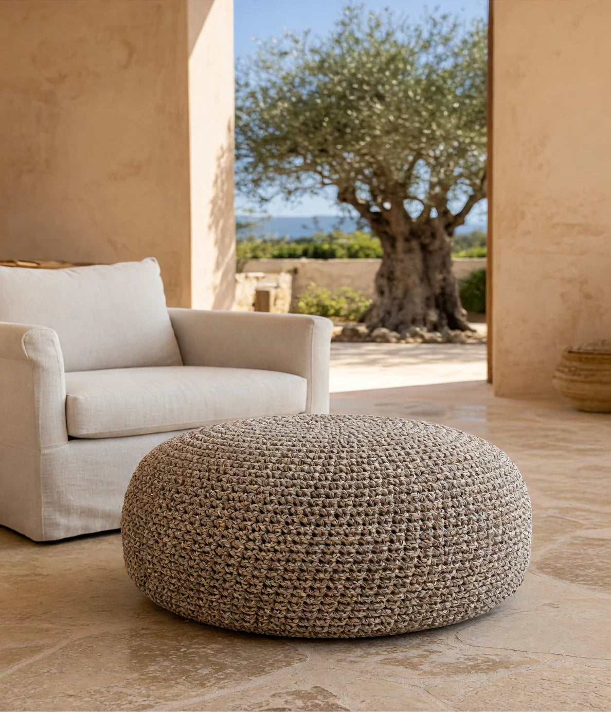 Beige and brown Looping Home crochet pouf in a limestone living room